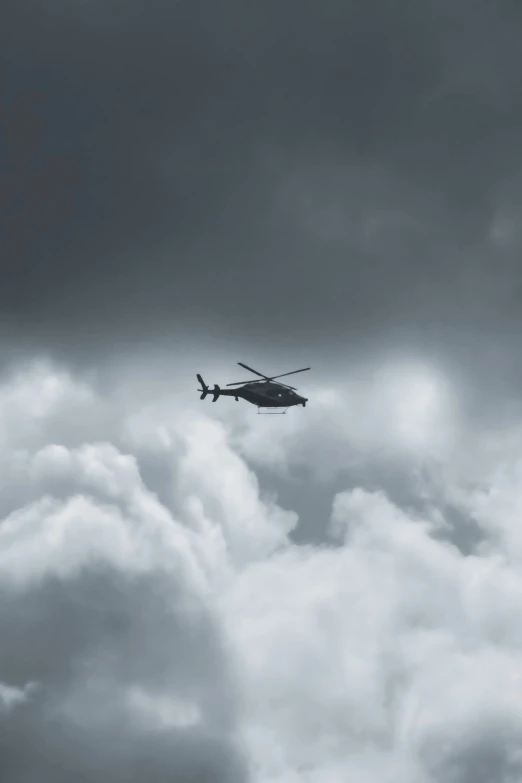 a helicopter is flying in the air with clouds