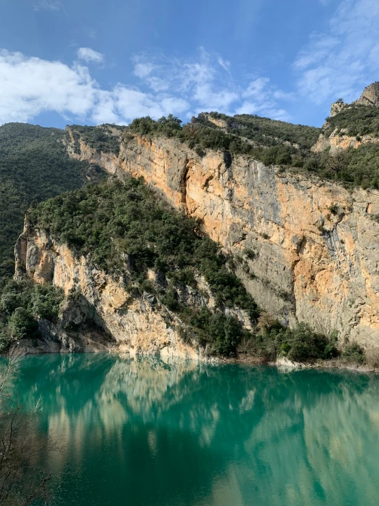 green water in a mountain lake near a cliff