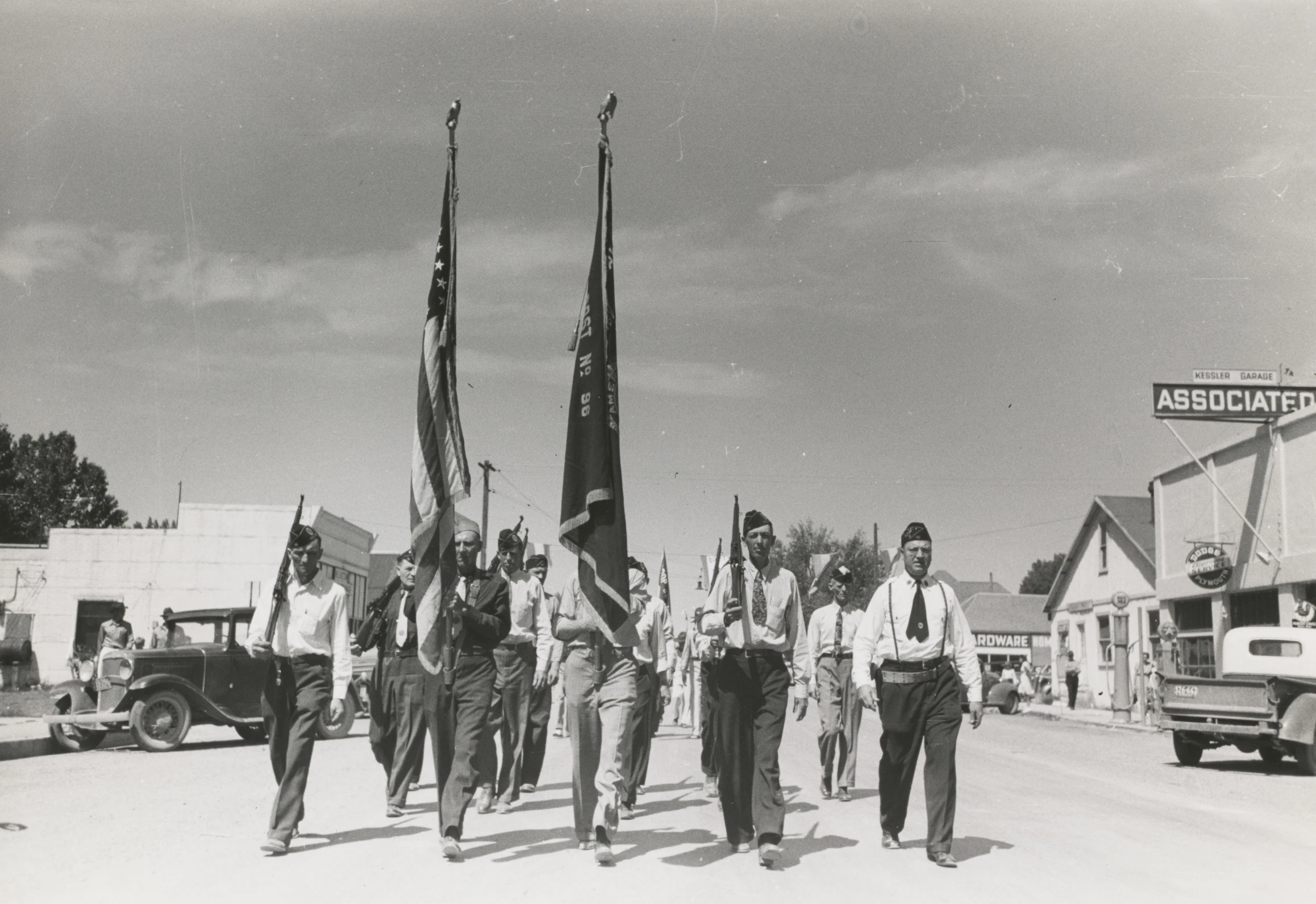 some guys are walking down the street with flags