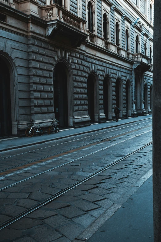 a train traveling down an empty street next to two buildings