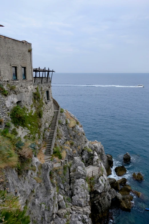 a group of people standing on top of a cliff next to the ocean