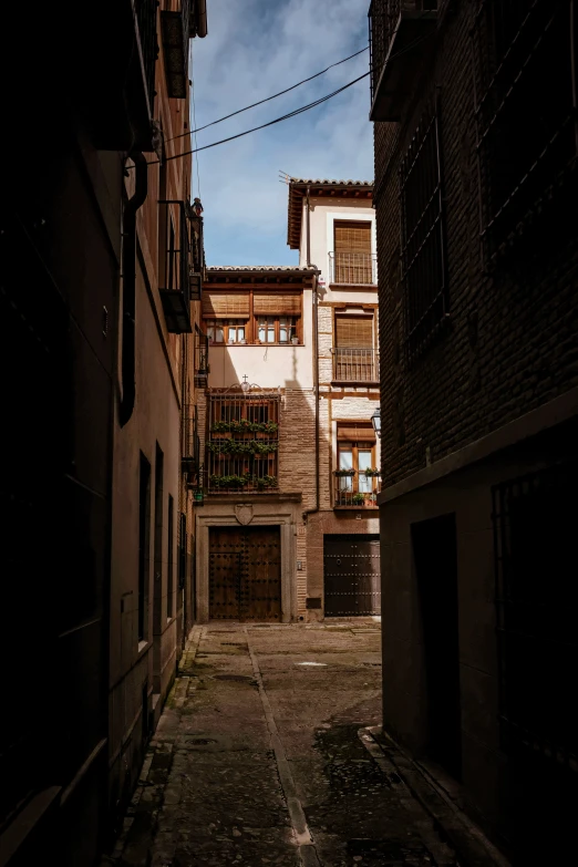 a dark alley that has brick building behind it
