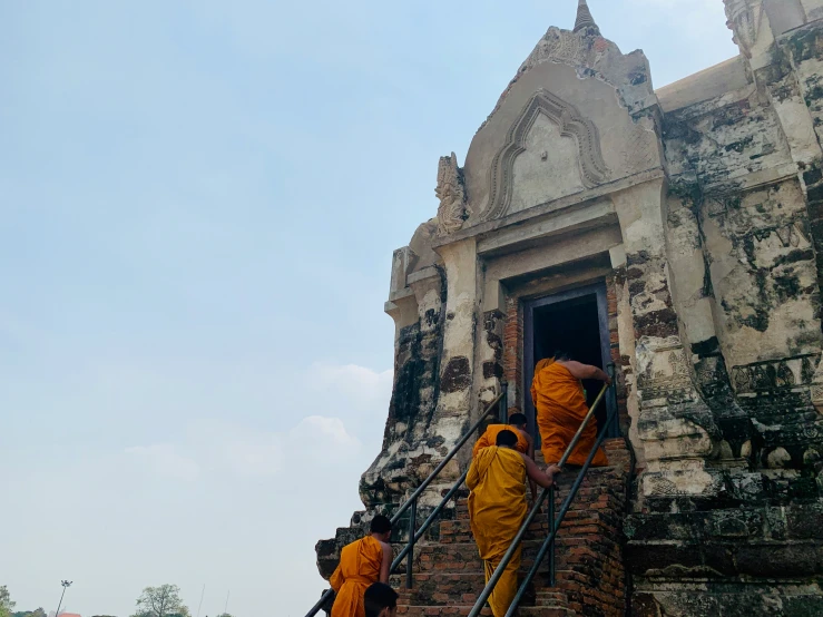 a group of monks climb up some steps to get to a building