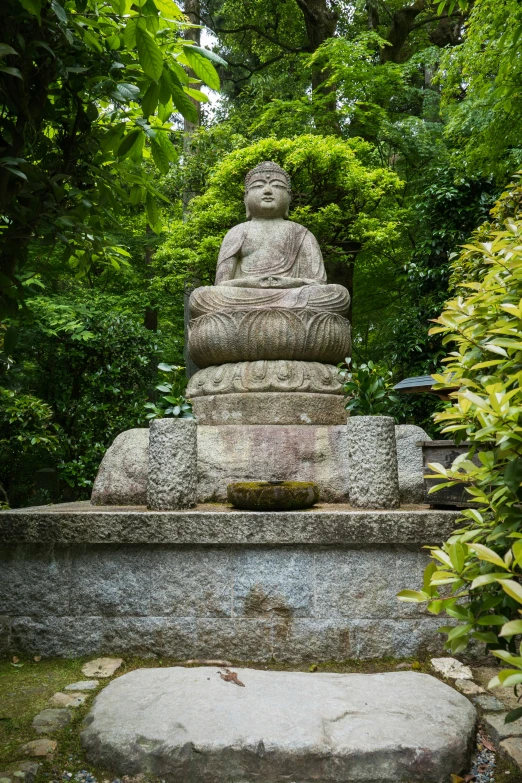 a stone garden statue surrounded by greenery