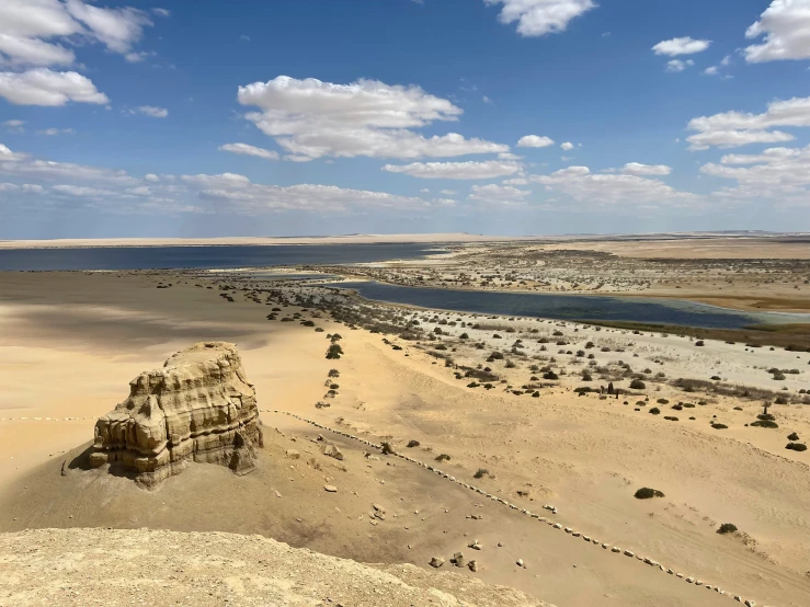 a desert with water and sand on a beach