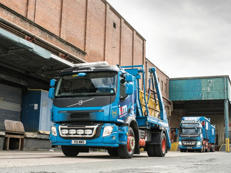 some big trucks parked near a building under construction