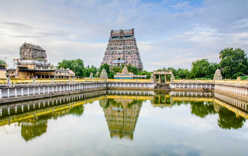 an outdoor pond sits in front of a tall tower