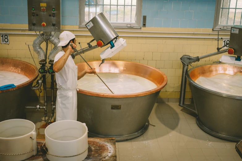 a person with a mixer in front of some barrels