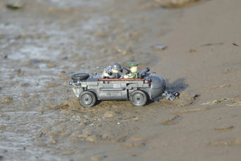 the toy car is driving in the water on the beach