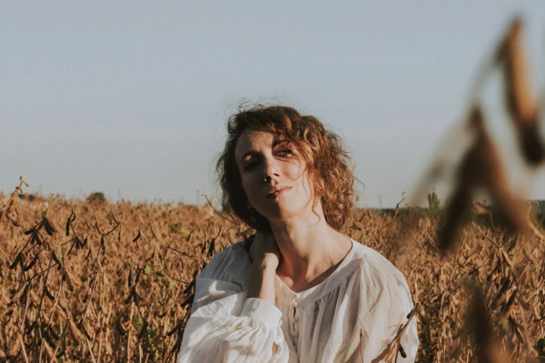 the young woman is standing in a field