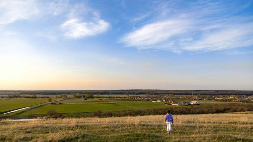 a woman is standing in a green field