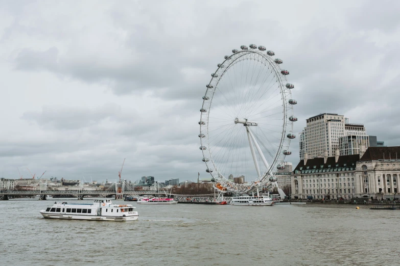 a large ferris wheel on top of a city near a body of water