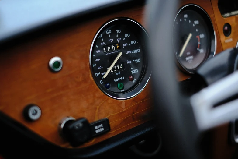 a dash gauge of a car in front of a steering wheel