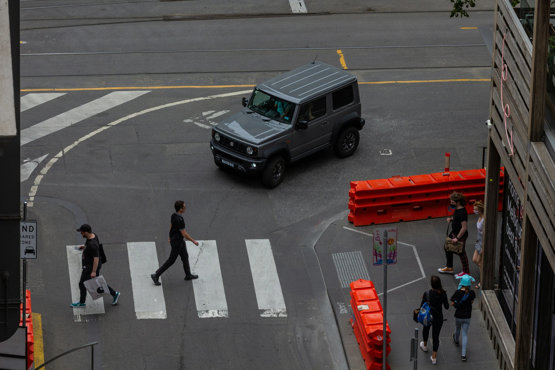 people are walking on the street near a van