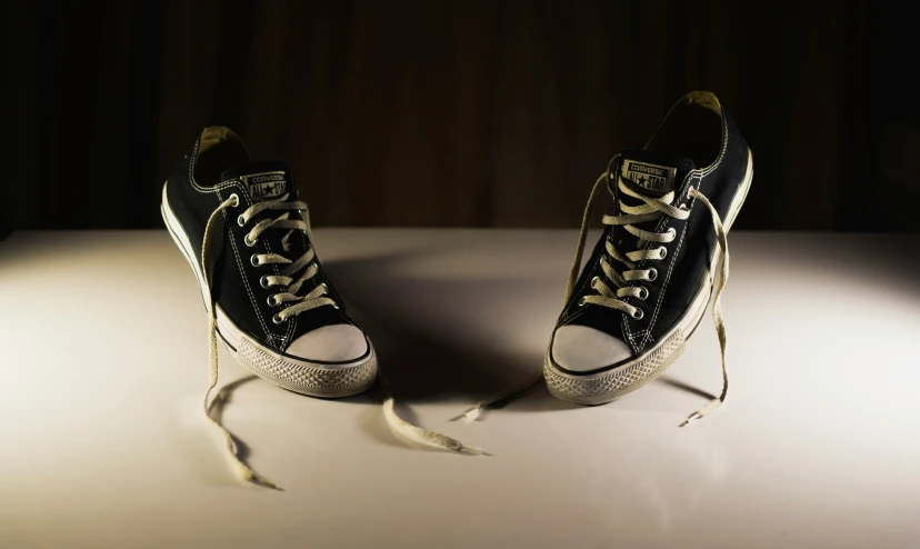 a pair of shoes sit on a table and the feet are laced up