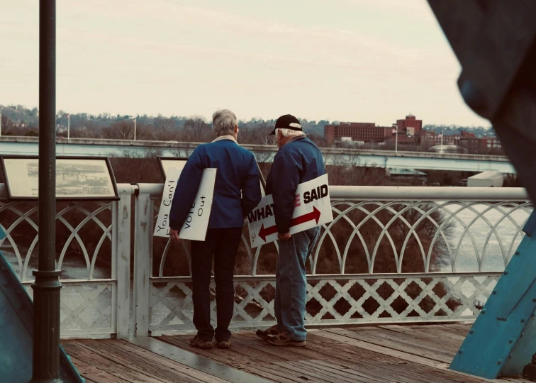 two men standing on a bridge on a foggy day