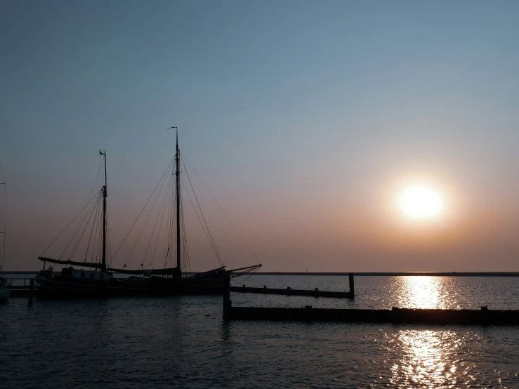 boat sitting on a dock during the sun set