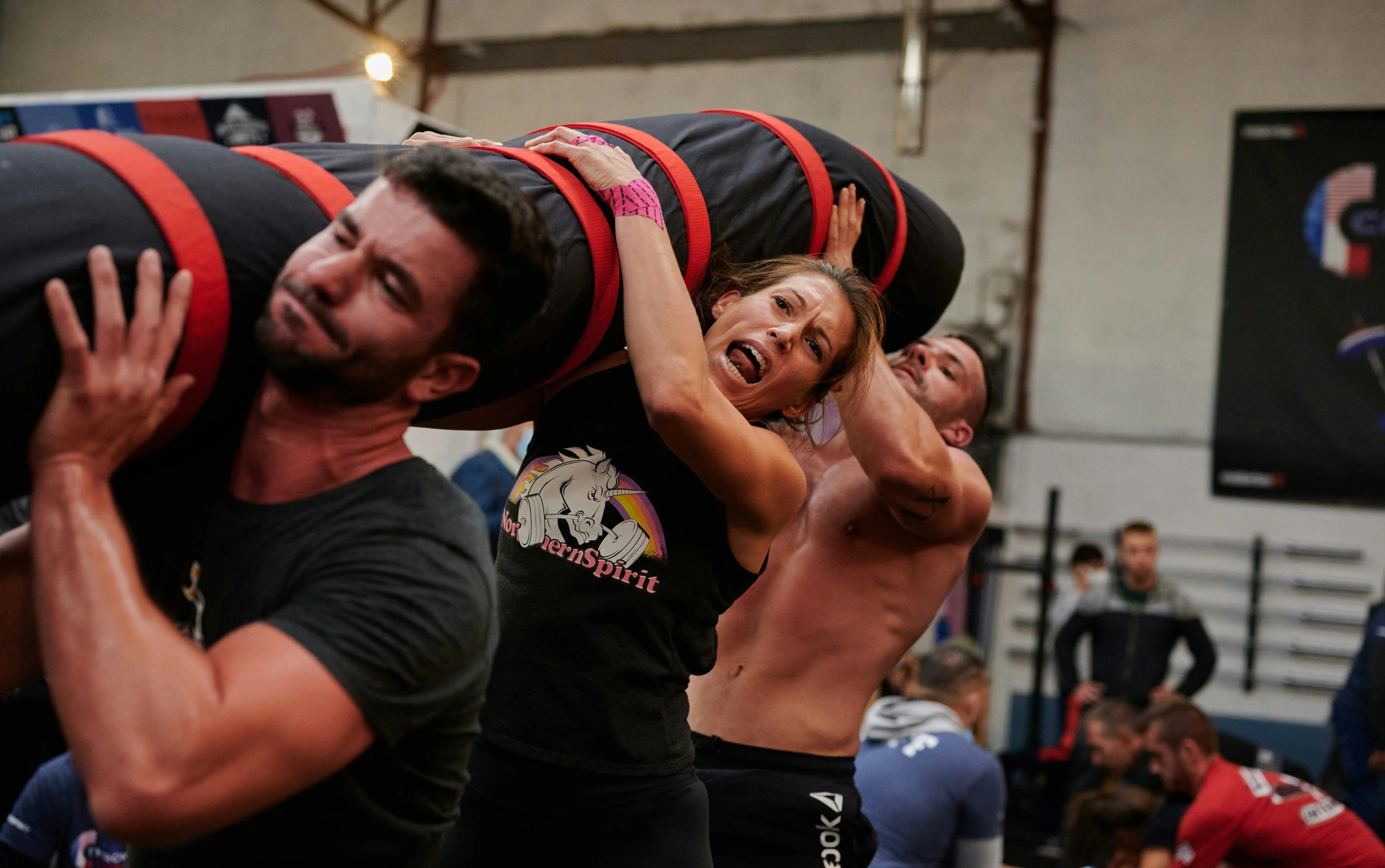 the crossfit athletes perform exercises with a young woman