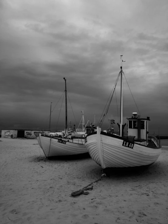 two boats on the beach next to each other