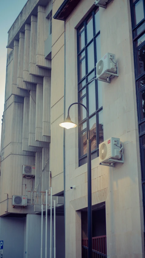 the corner of a building with multiple windows next to a street light