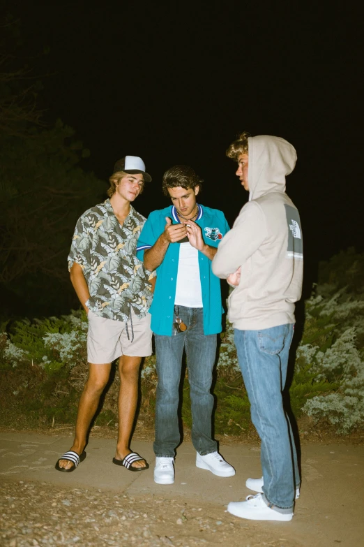 a group of people standing on a road at night