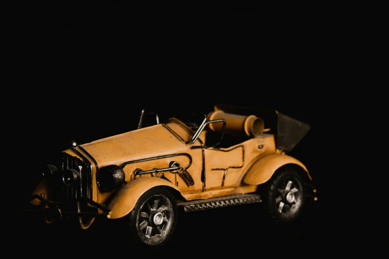 an old yellow model car with some lights on
