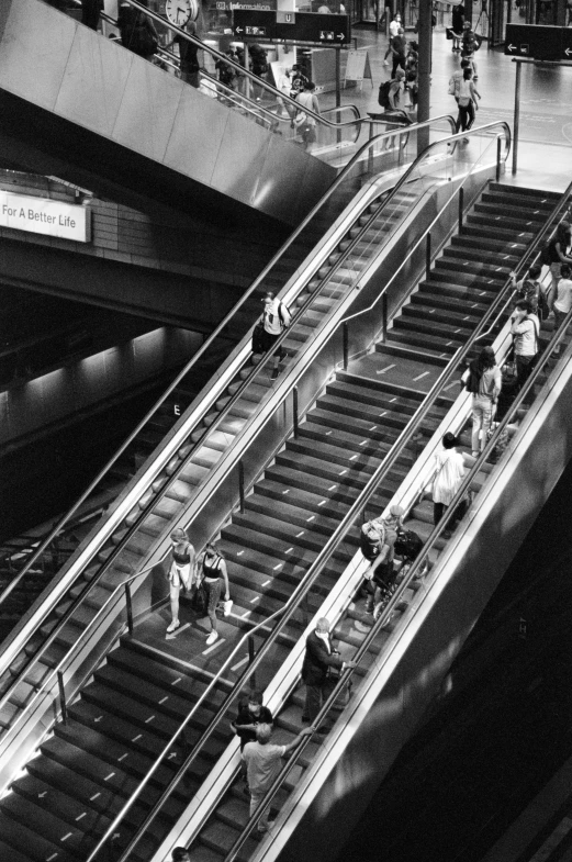 a large group of people ride on the escalator