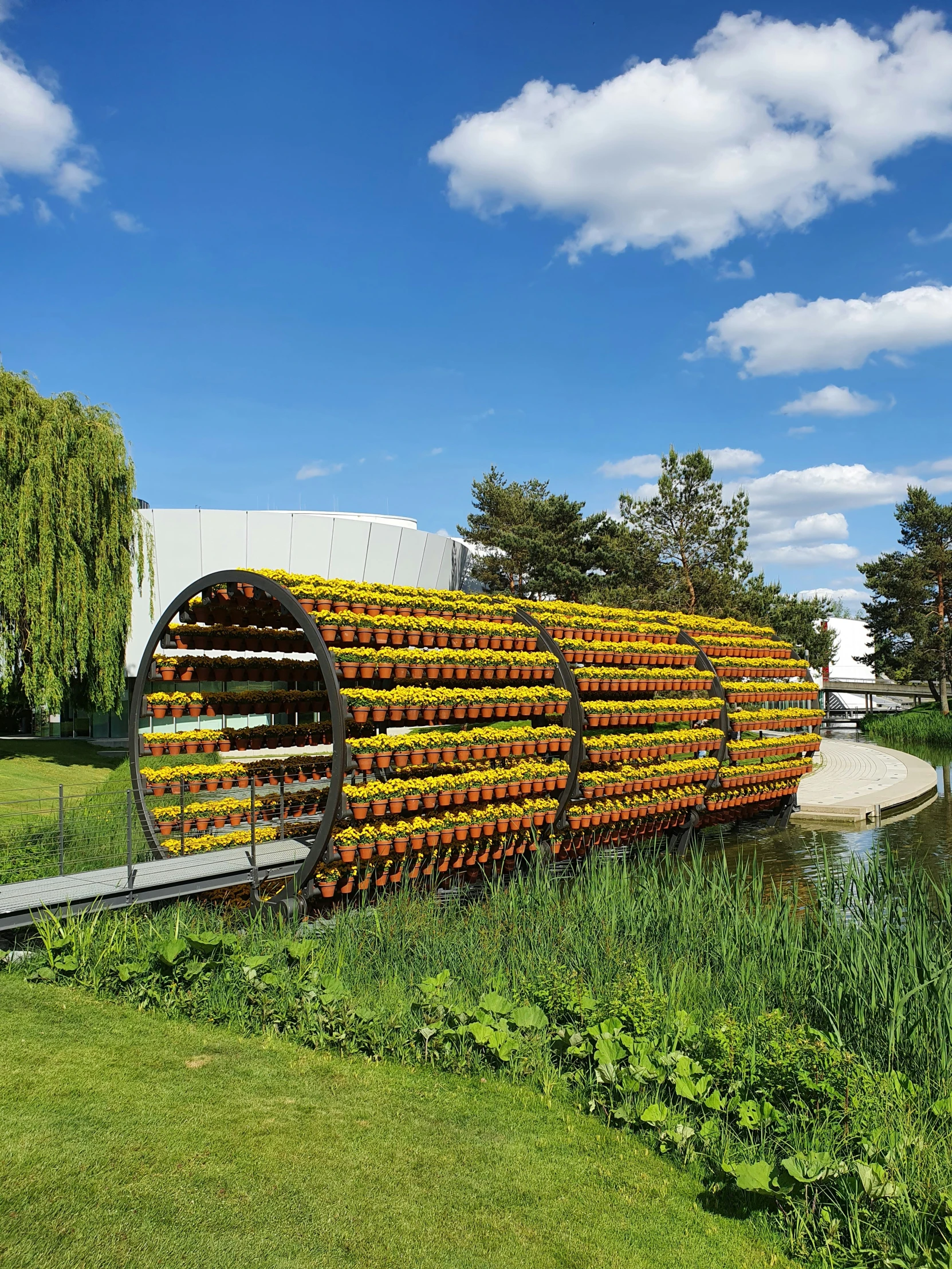 a large sculpture sitting in the grass near a lake