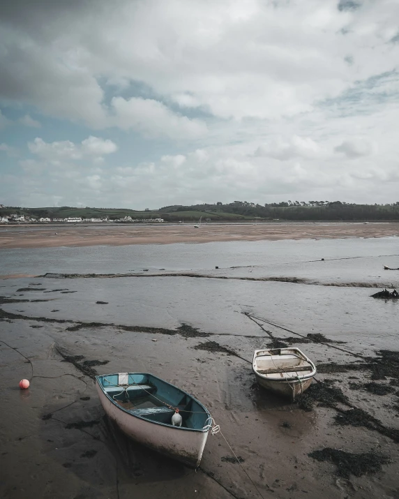 two small boats on wet beach with cloudy skies