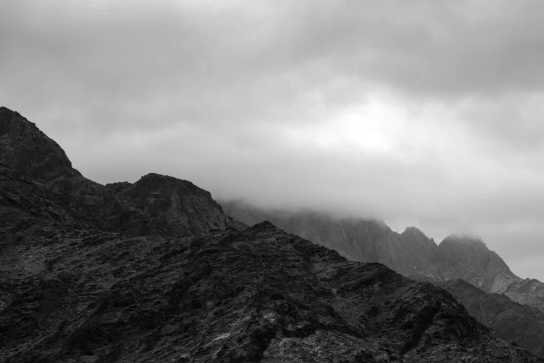 some mountains in the distance under a cloudy sky