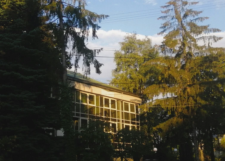 a large yellow building with glass windows in the woods