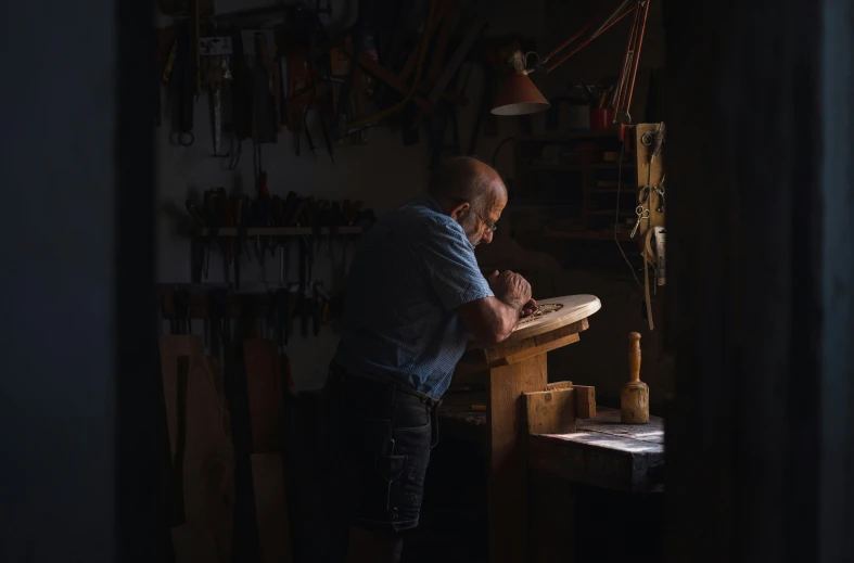 a man using a piece of wood with a wooden table