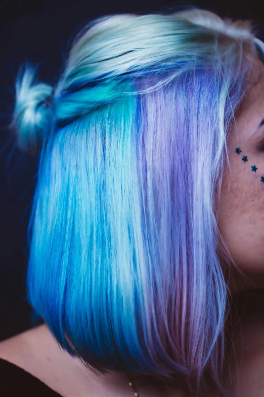 a woman with blue and purple hair wearing eye makeup