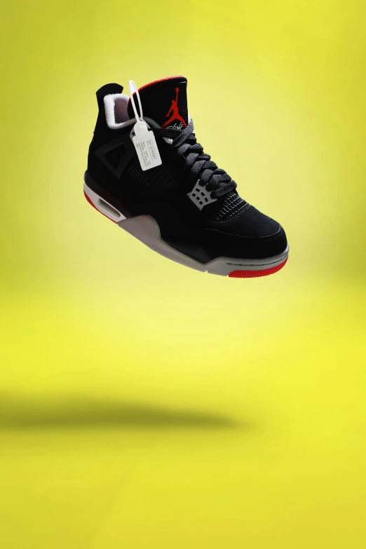 a black and red basketball shoe flying in the air