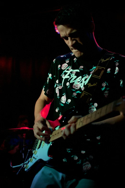 a man playing a guitar in a dark room