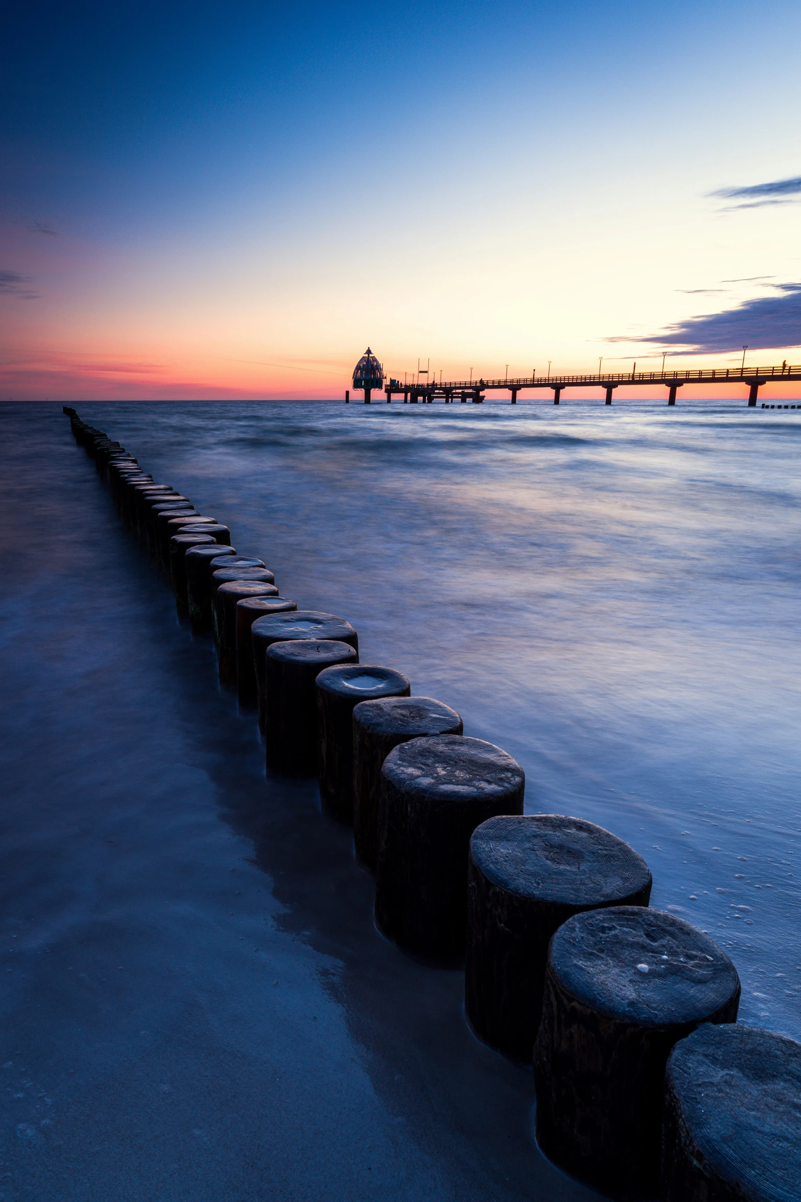 the view is of the beach with a row of poles in it