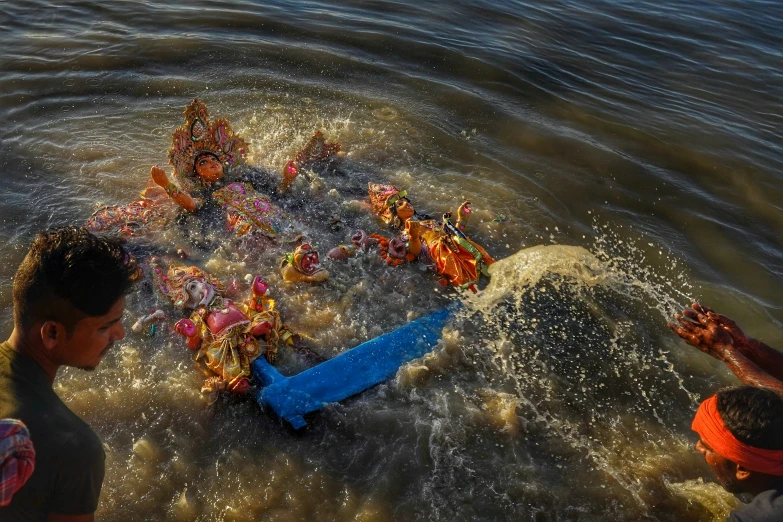 children splashing water onto the beach in a small lake