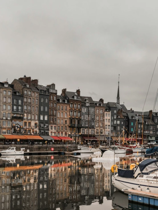 many small boats are docked near some tall buildings