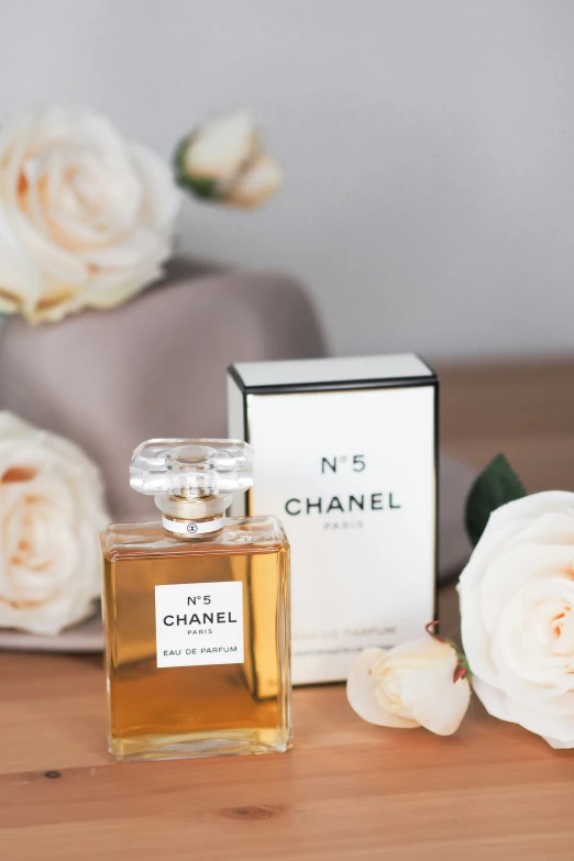 a bottle of chanel no 5 next to a box of flowers