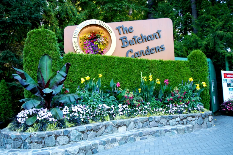 the sign for the orchard gardens is surrounded by plants