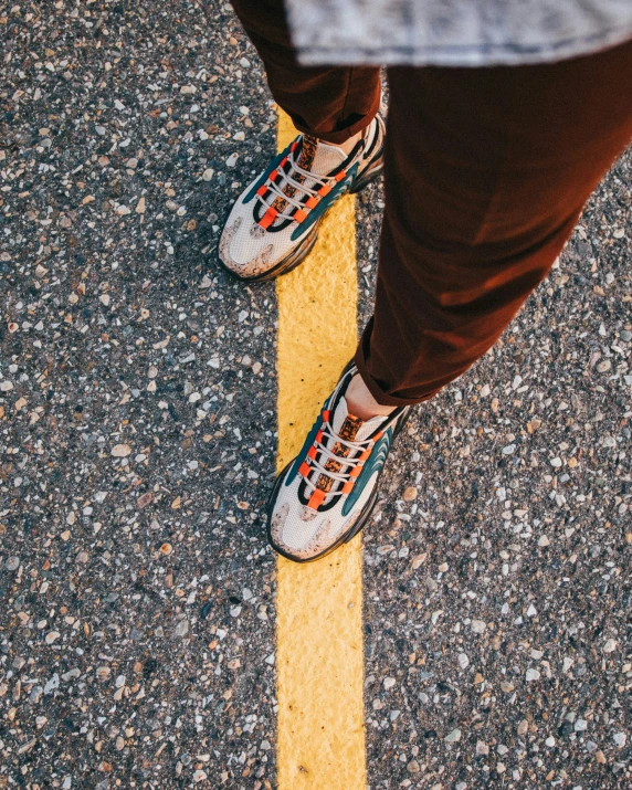 a person standing next to a yellow line with sneakers on