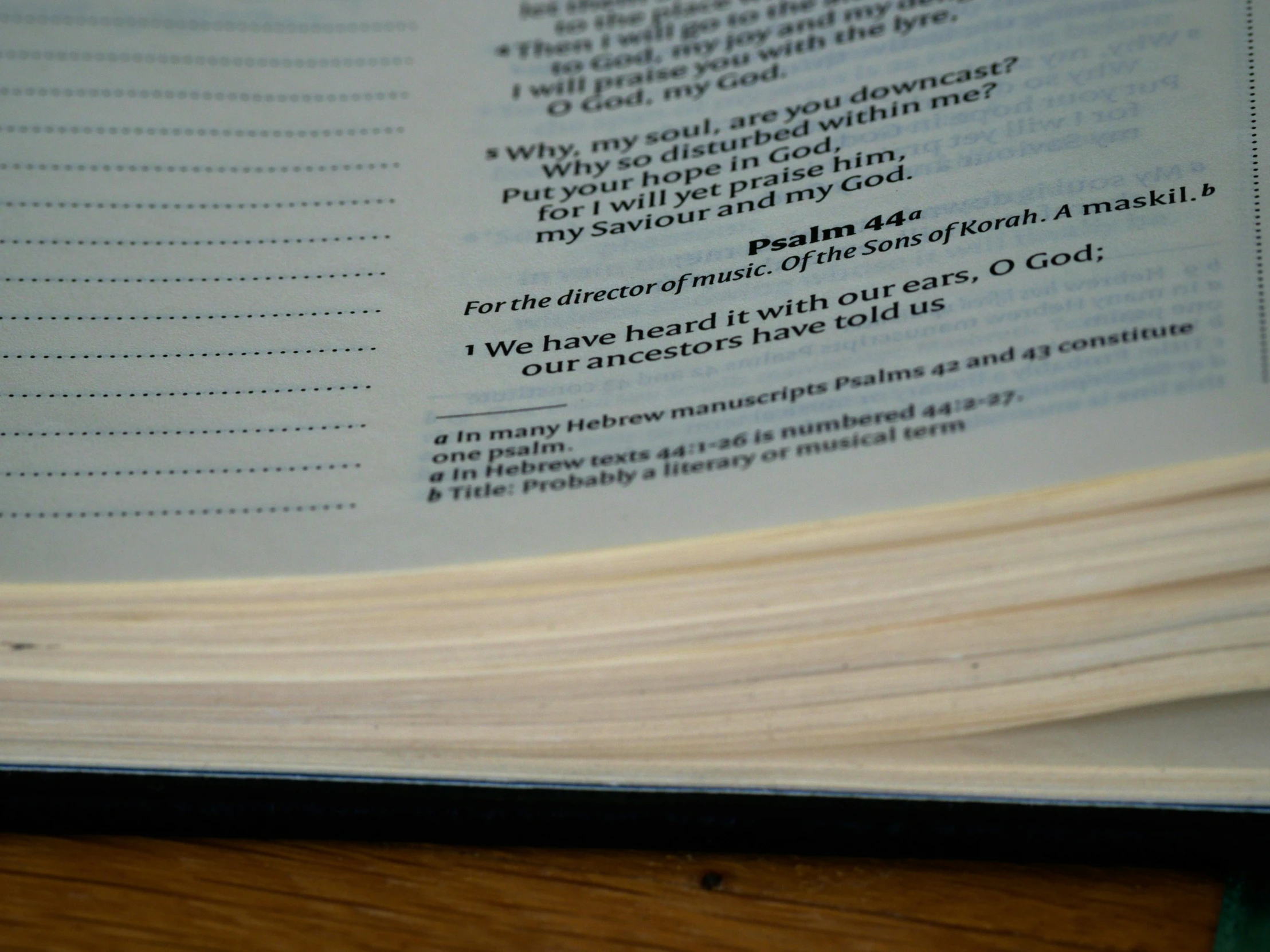 an open bible sitting on top of a wooden table