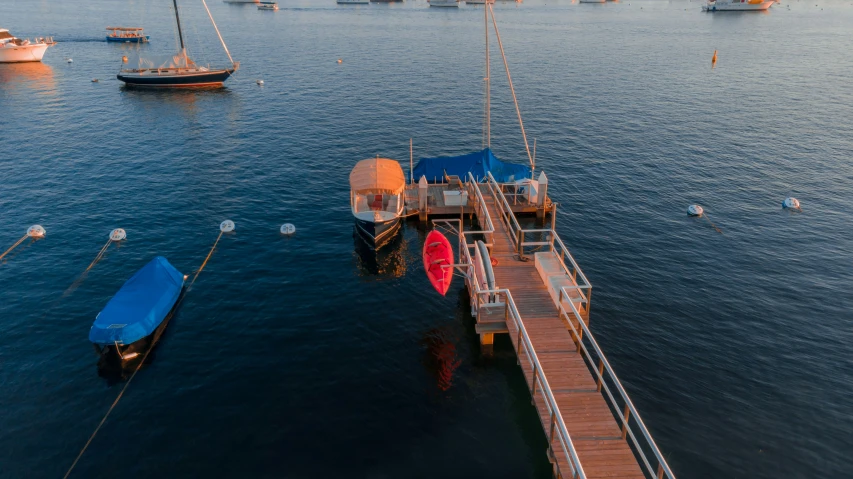 several boats are anchored in the water at the pier