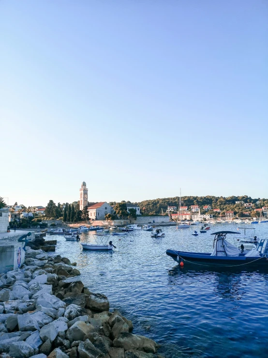 several boats are in the water near rocks and houses