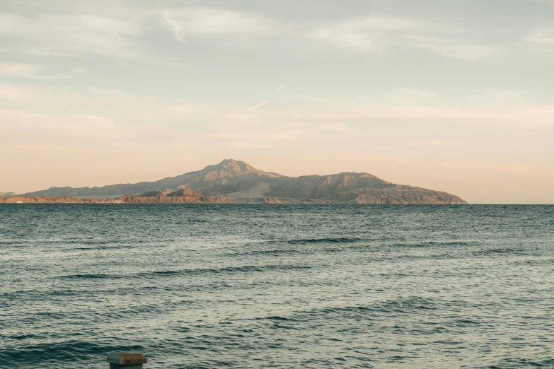 a lone boat on the water next to a shore