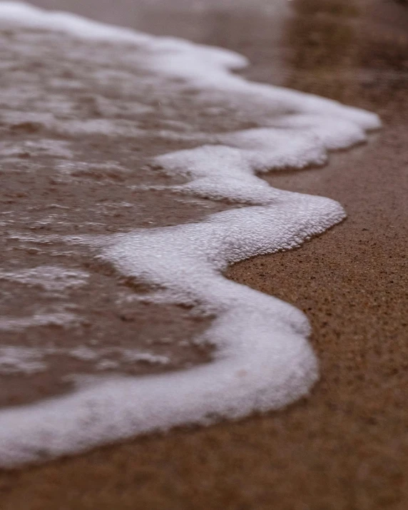 a close up po of some water waves on a beach