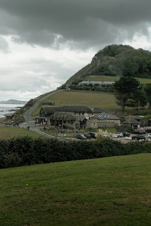 a lot of parked cars sitting on top of a lush green hillside