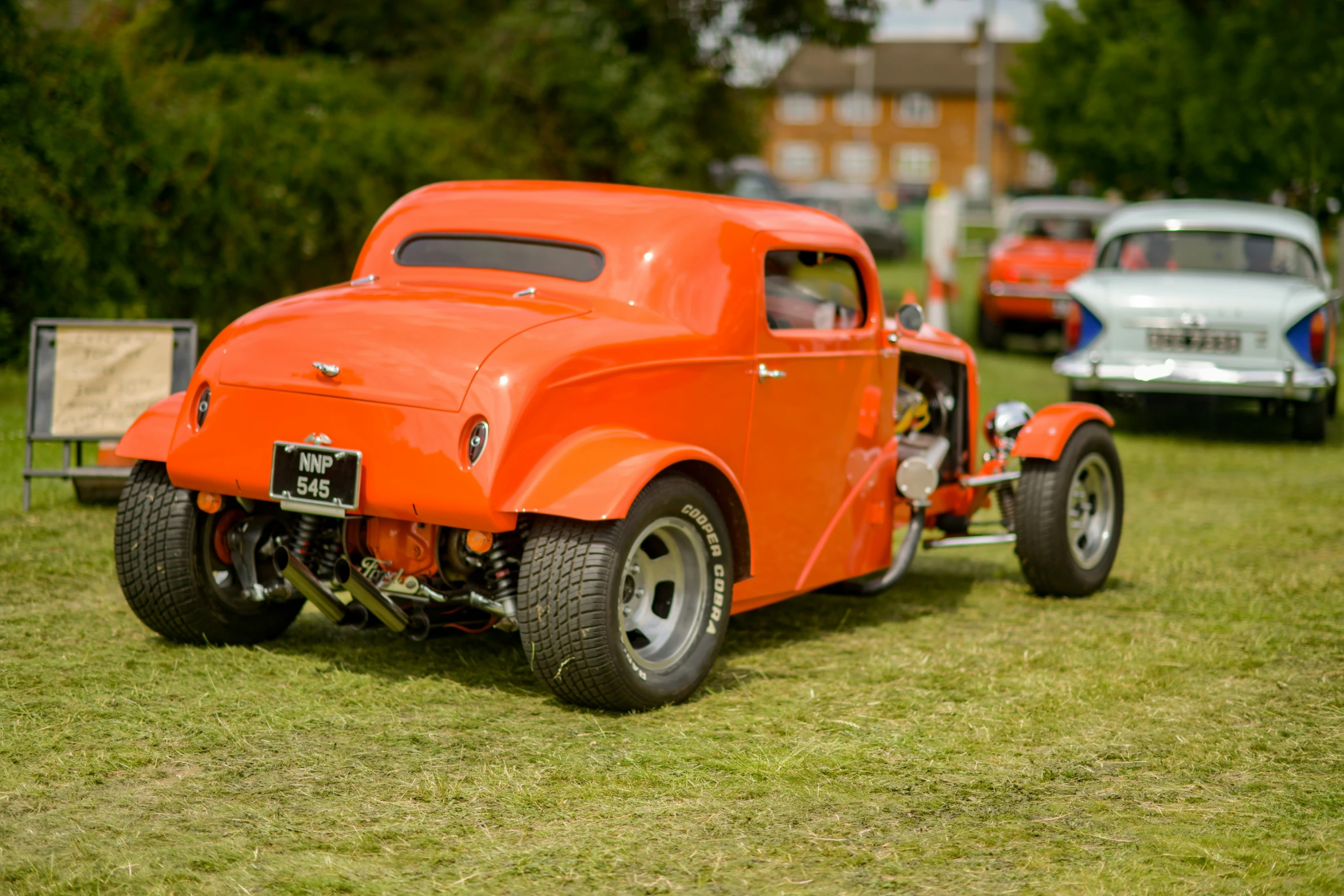 an orange pick up truck parked in the grass