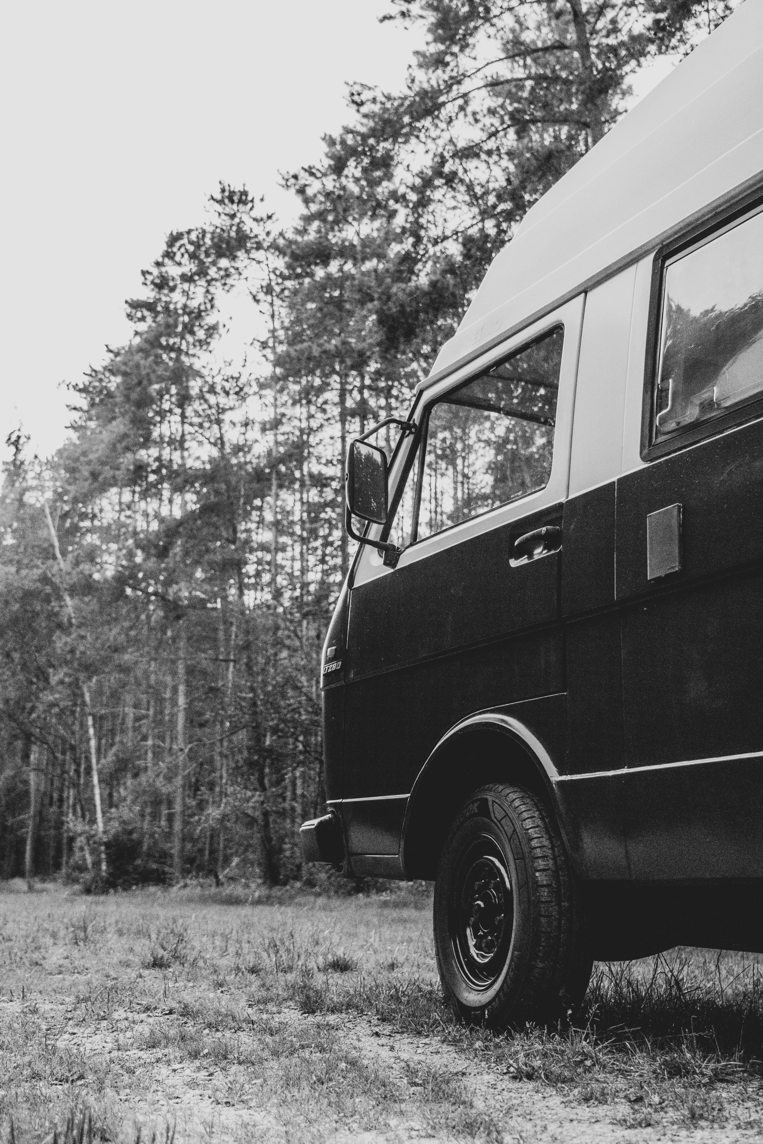 a van with a big truck and it's hood up parked on the grass