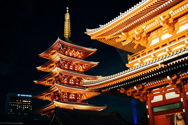 three tall asian buildings illuminated at night